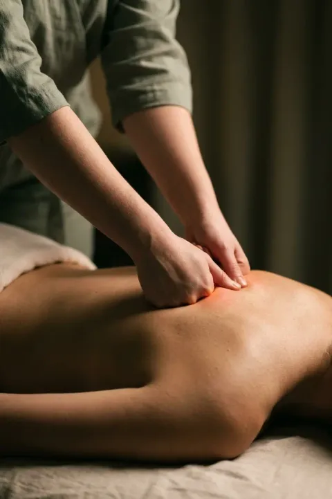 Therapist's hands working into the upper back during a deep tissue massage at Home Spa Latham